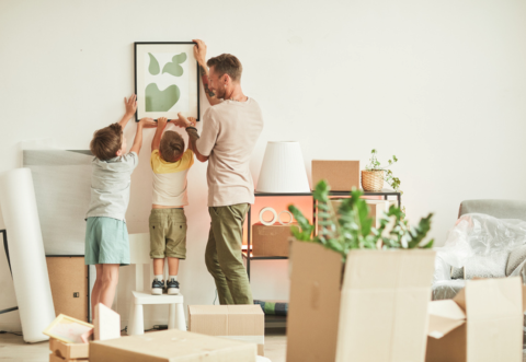 kids helping dad put up a frame on the wall