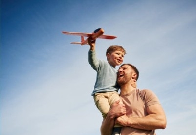father and son flying a toy plane